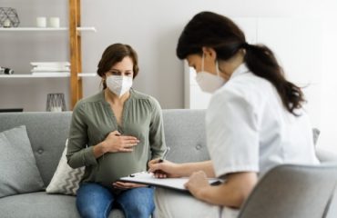 Schwangere Frau mit Atem"schutz"maske